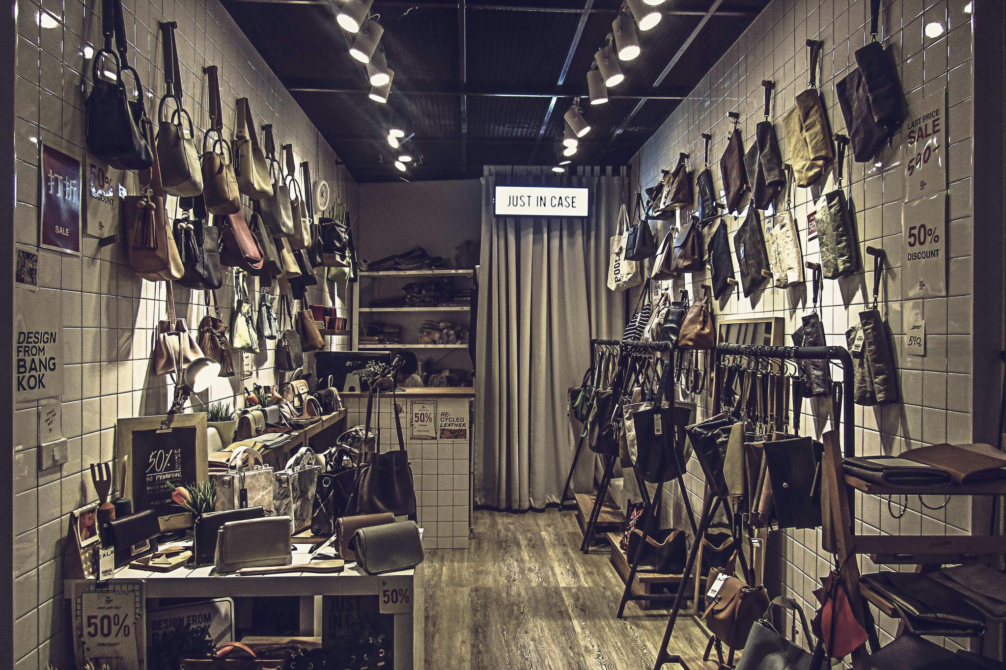 Stylish boutique store interior featuring an elegant collection of luxury bags displayed on tiled walls.